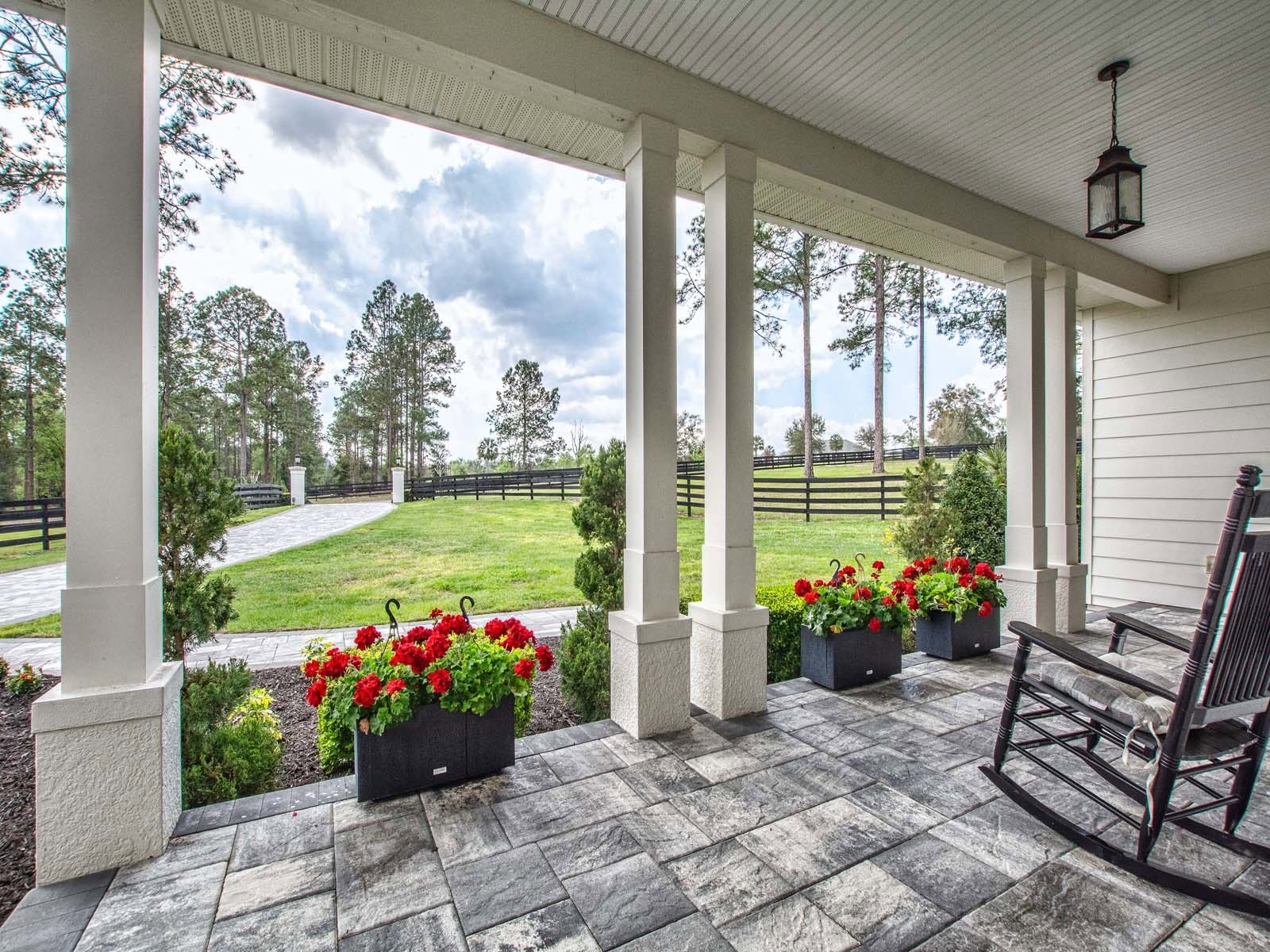 Front porch of a Mosco custom home with columns and flowers